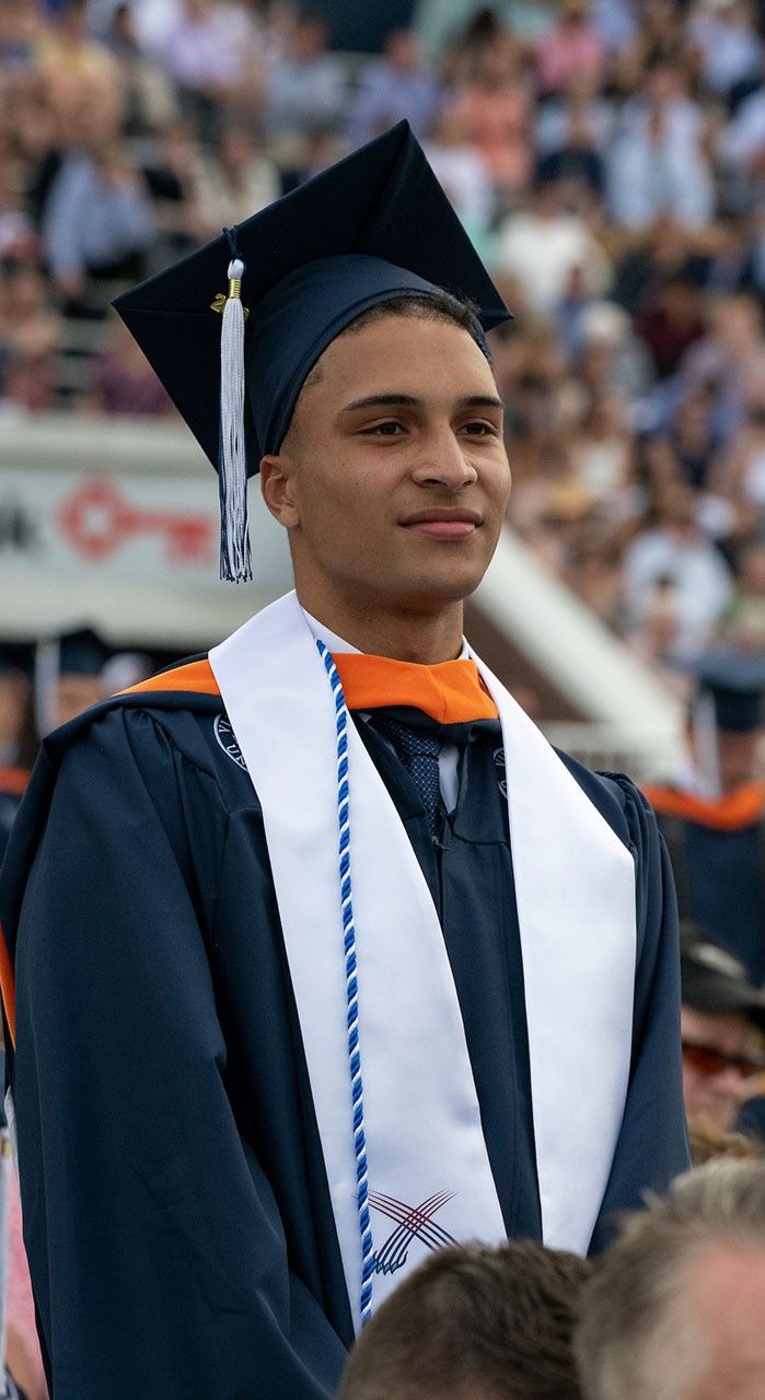 A student stands during Ӱԭ's commencement ceremony.